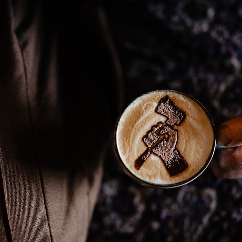 Chop it logo, hand holding an axe, in chocolate on a cappuccino